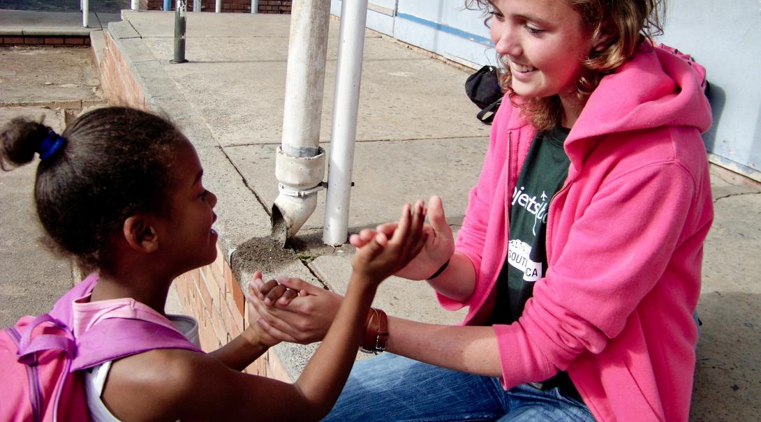 A Projects Abroad volunteer with children in South Africa plays a game during break time Childcare volunteer plays a game with a child during her volunteer work with children in South Africa